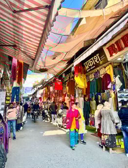 Vibrant street market in Rishikesh, India, filled with colorful stalls, local goods, and lively atmosphere.