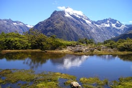 a mountain scene with a lake and mountains in the background