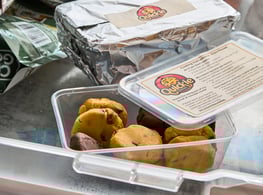 A box of frozen cookie dough pucks sit in a box in a freezer drawer.
