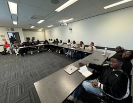 a group of youth sitting at tables in a room