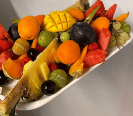 a platter of fruit and vegetables on a white plate