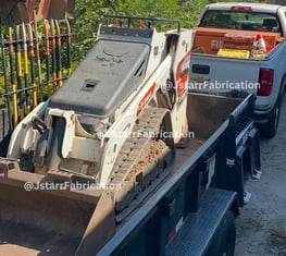 bobcat on top of a heavy duty trailer 