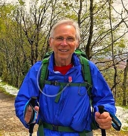 a man in a blue jacket and a backpacker