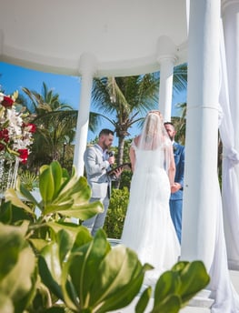 a bride and groom standing in front of a gazeboar