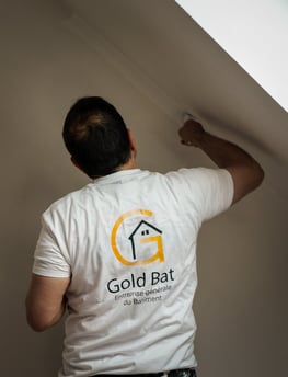 a man in a white shirt is painting a wall
