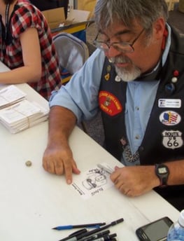 Caricature artist drawing biker cartoons at rally.