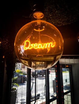 a neon sign that says dream in a glass ball