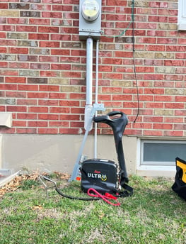 Utility location equipment leaning against a power utility meter