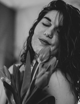 a woman with long hair and a flower in her hands
