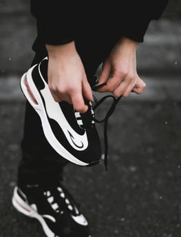a person holding a pair of shoes in their hands