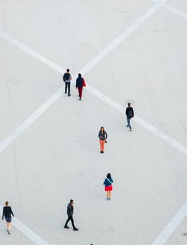 a group of people walking around a square with umbrellas