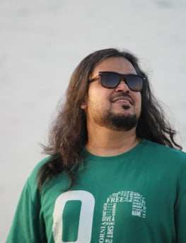 ध्यानपूर्ण मुद्रा में समुद्र की ओर देखते हुए एक व्यक्ति – आत्म-चिंतन और शांति की झलक