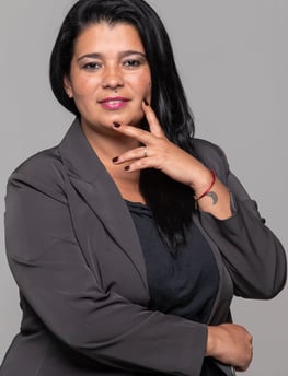 a woman in a gray suit and a red bracelet
