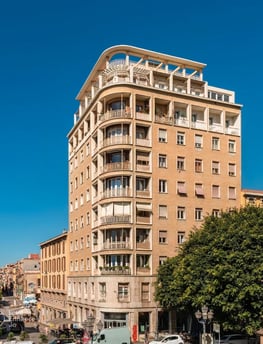 a large building with a lot of windows and a lot of cars parked on the