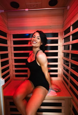 woman in a black swimsuit sitting in a infrared sauna ms bikini olympia international jennifer dorie