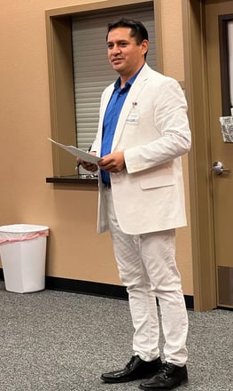 a man in a white suit and blue shirt