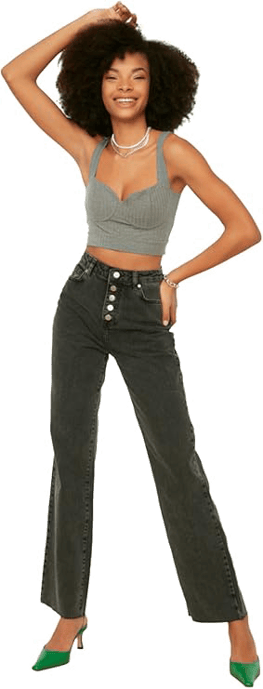 femme en jean debout bras sur la tete