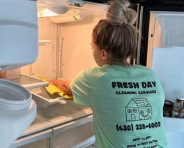 A professional cleaner thoroughly cleans inside of fridge