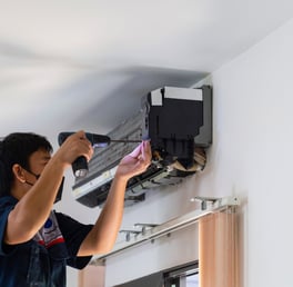 a man is fixing a air conditioner