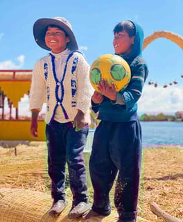 Portrait of two Peruvian children playing with a ball on the Uros Islands, Lake Titicaca.