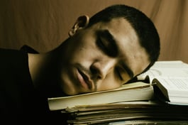 jeune homme fatigué, la tête sur ses livres