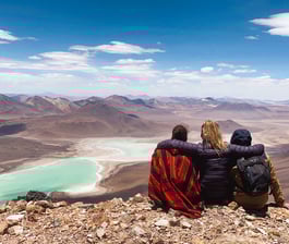 Photo de trois amis de dos face à la Laguna Verde depuis le sommet du volcan Licancabur.