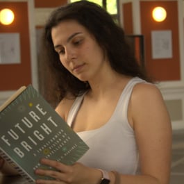 Femeie absorbită în lectura unei cărți în timpul unei întâlniri a clubului de carte din Cluj-Napoca
