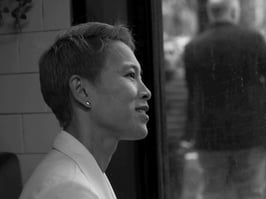 An attractive woman smiles as she talks to her friend.