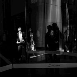 Several people are partially illuminated by sunlight.
