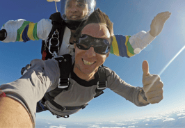 a man and a woman are skydiving in the sky