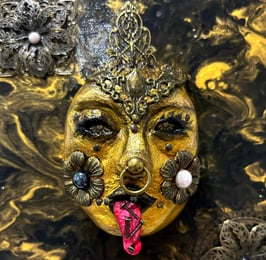 a gold mask with a face made out of gold leaf