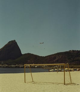 a soccer goalie on a beach with a plane flying over it
