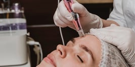 a woman getting a facial lift in a beauty salon microneedling