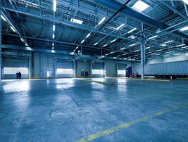 a large warehouse with a truck parked in the middle of the floor