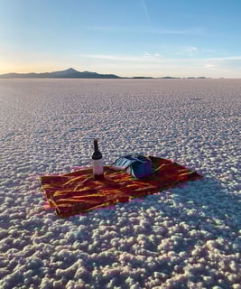 Bouteille de vin sur un plaid dans le Salar de Uyuni en Bolivie.