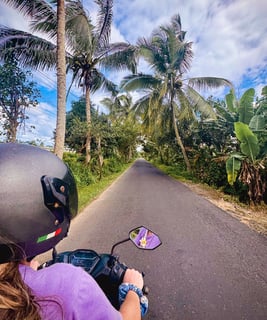 Photo of me riding a scooter along a scenic road in Nusa Lembongan.