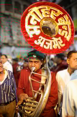 A member of the Manohar Band playing a French horn during a performance.