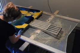 a woman is painting a large piece of art