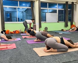 Yoga class in India with Eva leading the session as the teacher.