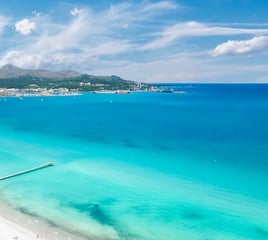 Scenic view of Alcudia Bay on a clear day, popular boat tour destination in Mallorca