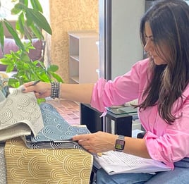 Sigal, founder of Solo Home Decor, selects fabrics while designing custom furniture.