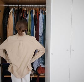 a woman standing in a closet with a closet full of clothes