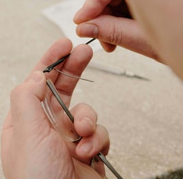 les mains d'un opticien qui change une branche de lunettes.