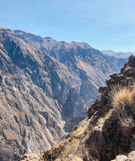 View of the Colca Canyon near Arequipa, Peru, with steep cliffs and a clear sky.