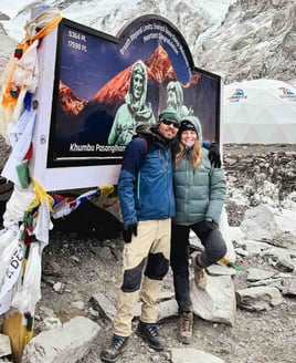 Manon et son guide népalais devant le panneau du camp de base de l’Everest, Népal.