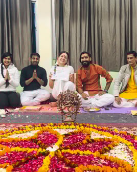 Eva standing with her yoga teachers during the diploma ceremony in Rishikesh, all smiling and celebrating the completion of t