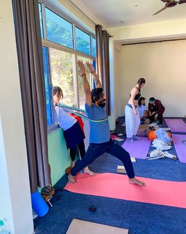 Yoga teacher leading a training class, guiding students through poses and techniques in a focused learning environment.