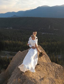 Eloping couple standing at the edge of a hoodoo