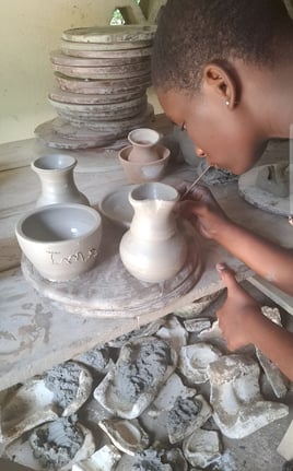 une jeune fille des ateliers créatifs fabrique des pots en poterie