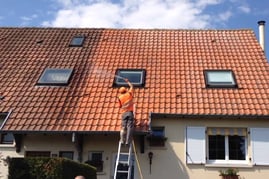 un homme qui traite une toiture
